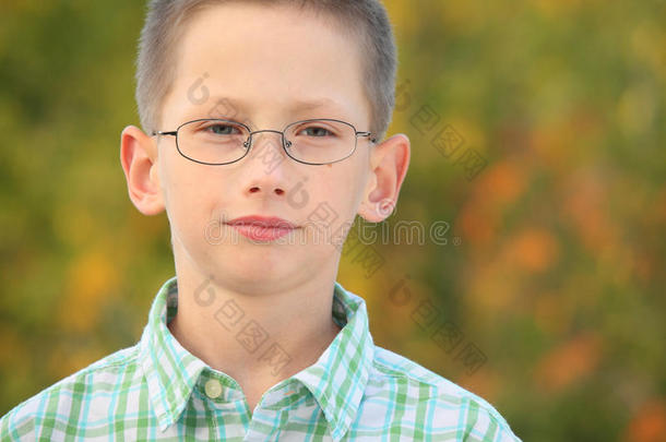 公园里戴眼镜的严肃男孩的画像