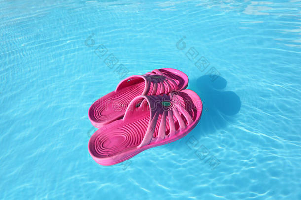 游泳池里在水上游泳的沙滩拖鞋