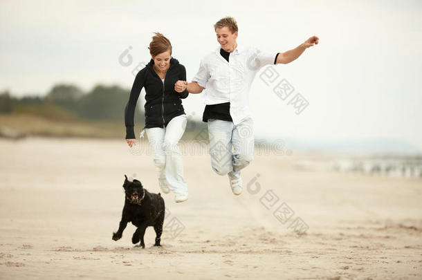 两个年轻人在沙滩上跳来跳去