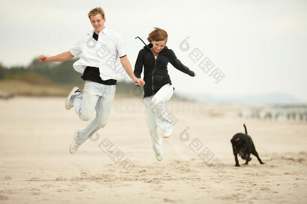 两个年轻人在沙滩上跳来跳去