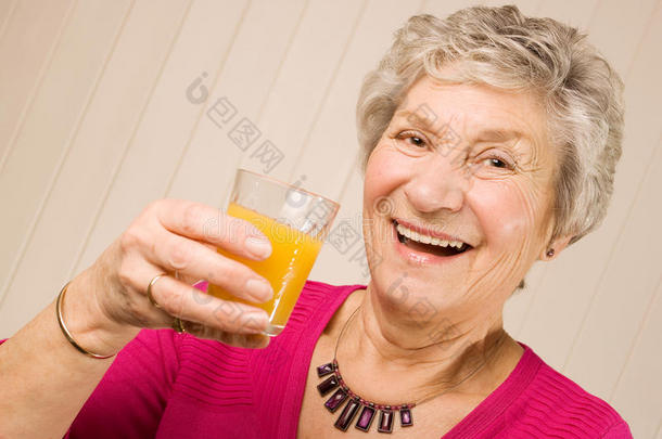 老太太拿着一杯橙汁