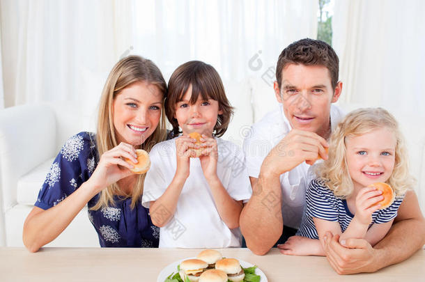 微笑的一家人在客厅吃汉堡