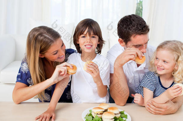 微笑<strong>的</strong>一家人在客厅吃汉堡