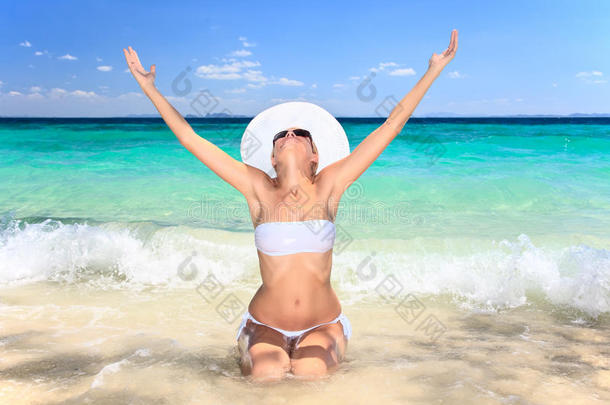 坐在沙滩上的妇女，双臂<strong>高举</strong>