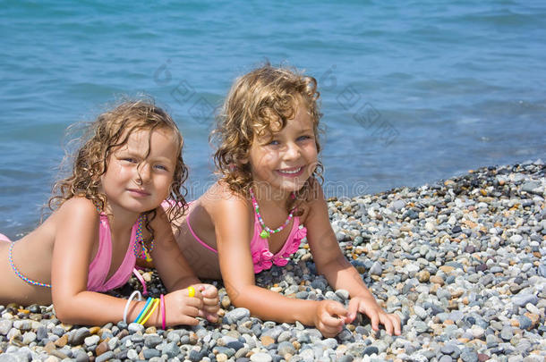 两个小女孩躺在石滩上