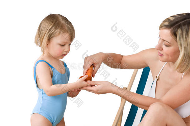 海滩-带孩子的母亲使用防晒乳液