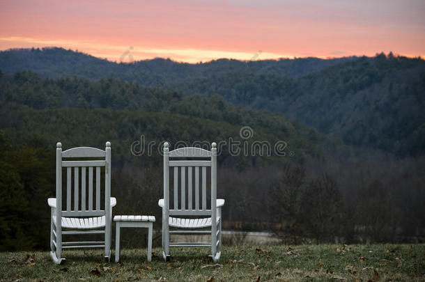 日落时俯瞰群山的椅子和桌子