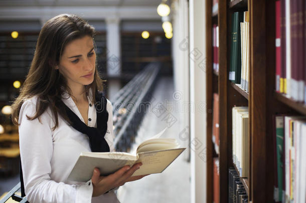 在书架上看书的女人