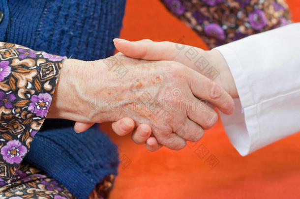 年轻可爱的医生握着老妇人的手