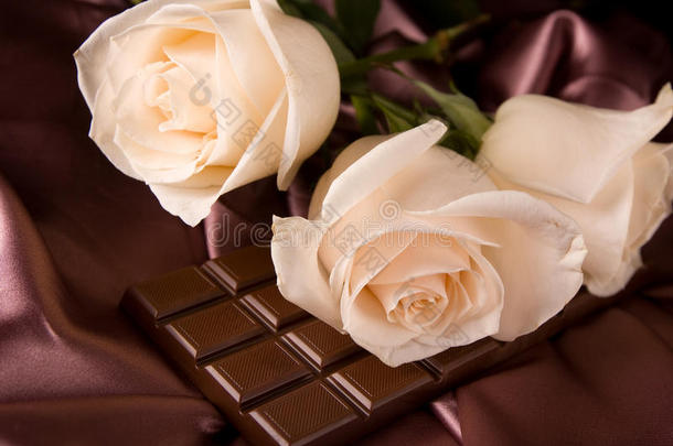 棕色丝绸和巧克力上的白玫瑰