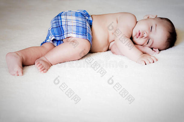 六个月大<strong>的婴儿</strong>睡在白色<strong>毯子上</strong>
