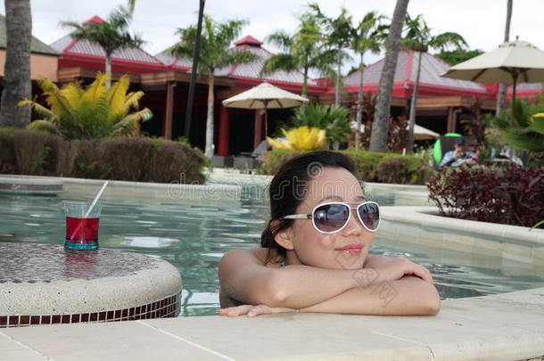 一个亚洲女孩悠闲地在游泳池里