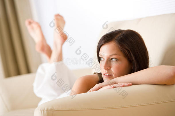 体贴的女人在沙发上的休息室里放松