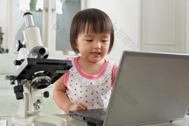 有笔记本电脑和显微镜的天才小女孩