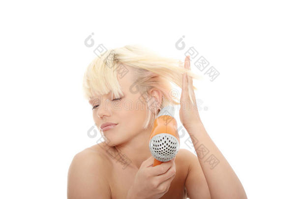 年轻的金发女人用吹风机