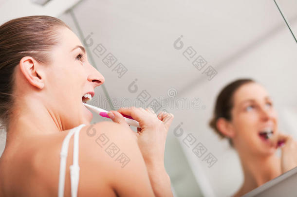 年轻女子在镜子前刷牙