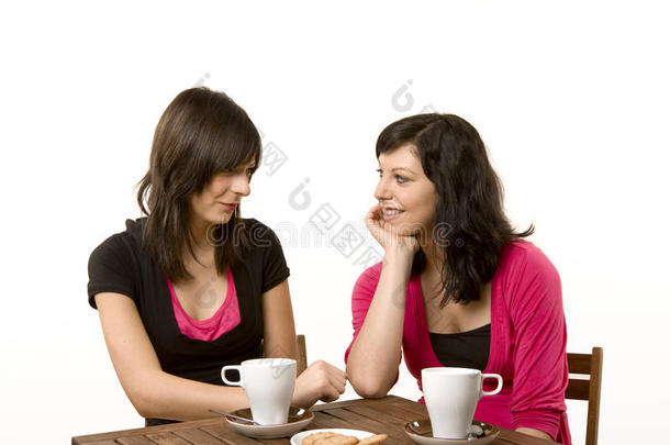 两个女孩边喝咖啡边吃蛋糕