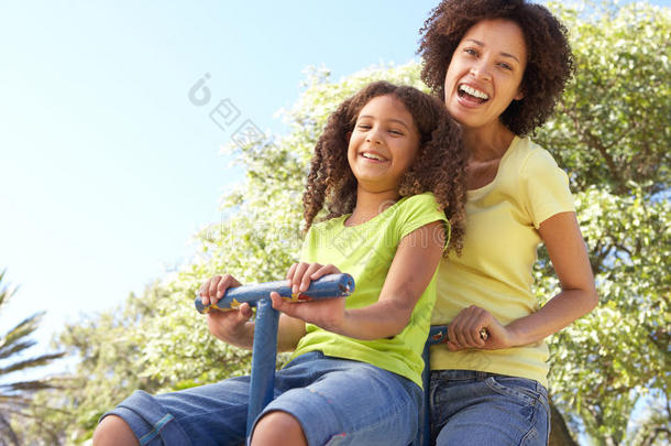 母亲和女儿在公园里骑<strong>跷跷板</strong>