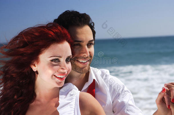 海滩上的一对年轻夫妇手拉手