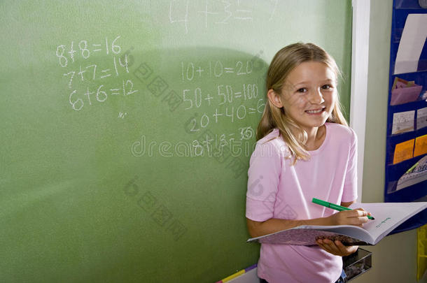 班上快乐的女孩在黑板上做数学
