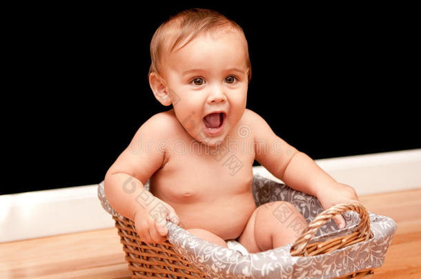 快乐的9个月大的婴儿在篮子里