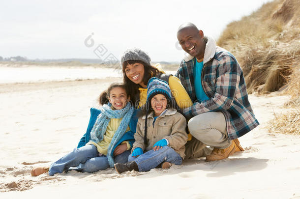 坐在冬日海滩上的一家人