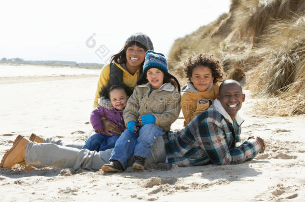 坐在冬日海滩上的一家人
