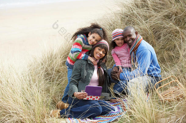 一家人坐在沙丘上享受冬天的野餐