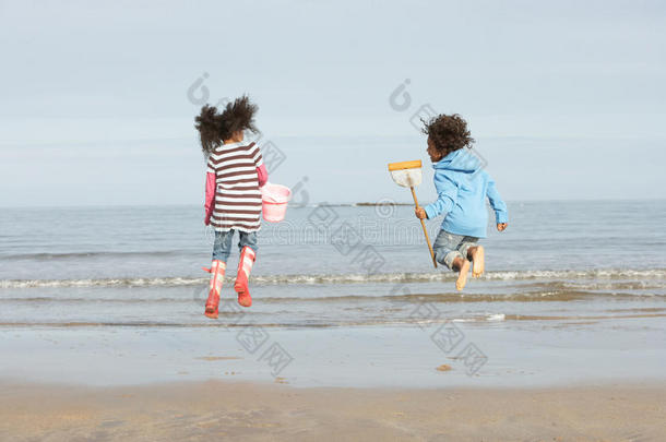 两个孩子在冬日海滩海边玩耍