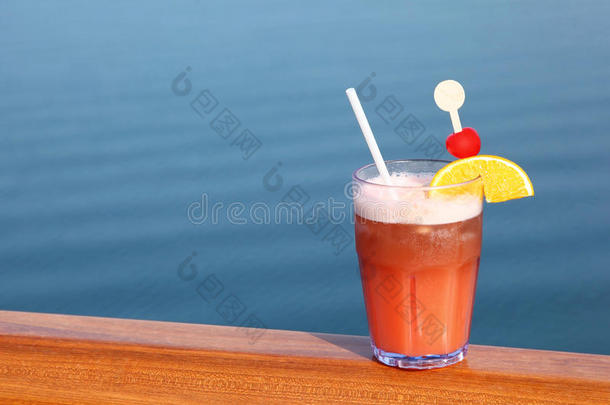 船上甲板栏杆上的玻璃水果鸡尾酒