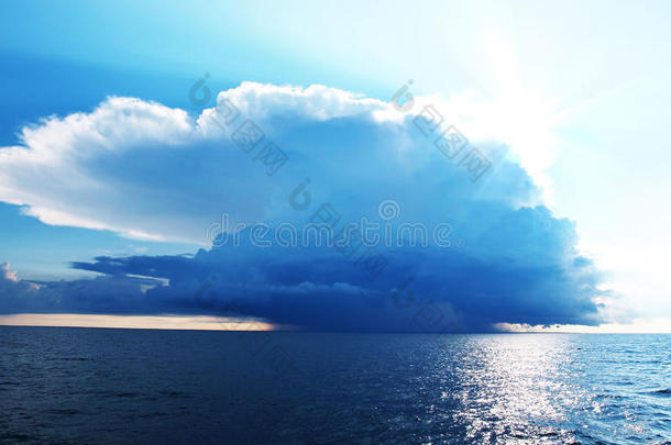 明亮的蓝天，暴风雨的云彩笼罩着大海