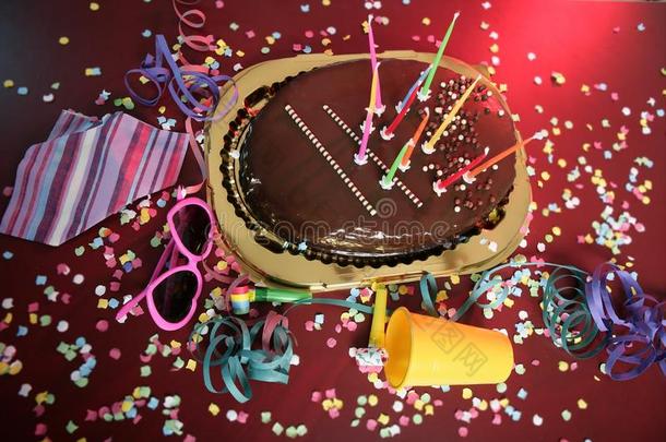 一张凌乱的桌子上放着巧克力节日派对蛋糕