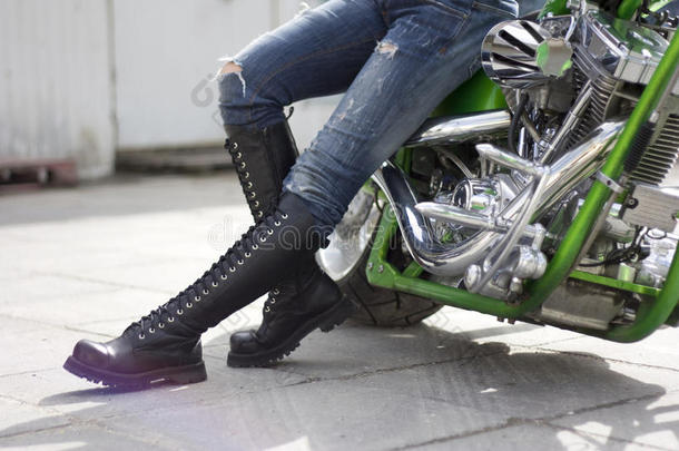 绿色摩托车和一个穿重靴子的女人