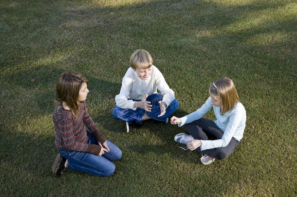 孩子们围坐在草地上聊天