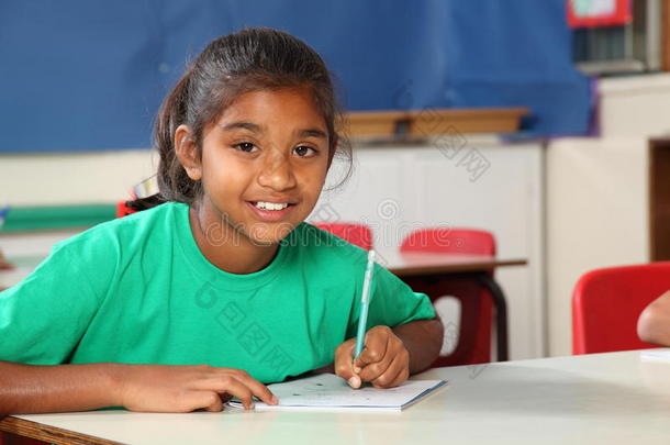 9岁的小女生在课桌上写字