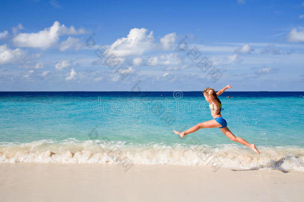 女孩在沙滩上跳来跳去