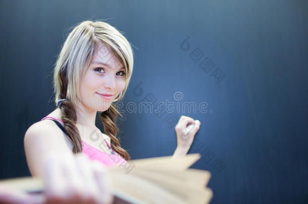 年轻大学生在黑板上写字