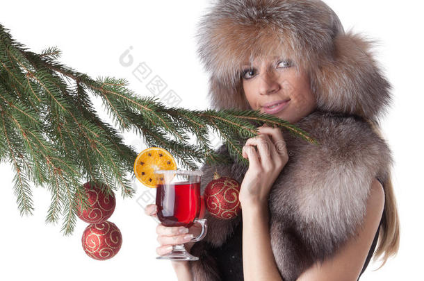 一个穿着皮草，端着一杯热葡萄酒的年轻女子。