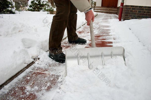 在人行道上铲雪的人