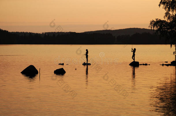 日落时分湖中的儿童钓鱼竿