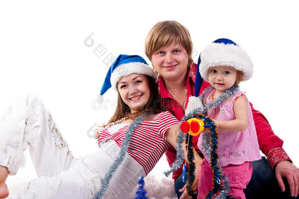 <strong>一家人</strong>戴着圣诞老人<strong>的</strong>帽子坐在人造雪里