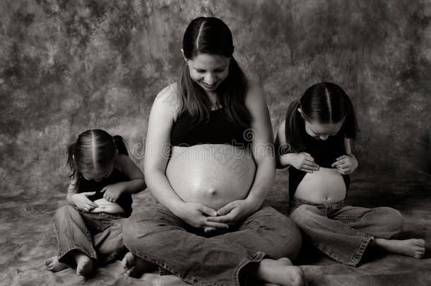 怀孕妈妈和小女孩比较肚子