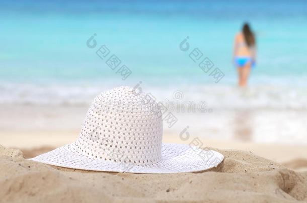沙滩上戴着白色太阳帽的女孩去游泳