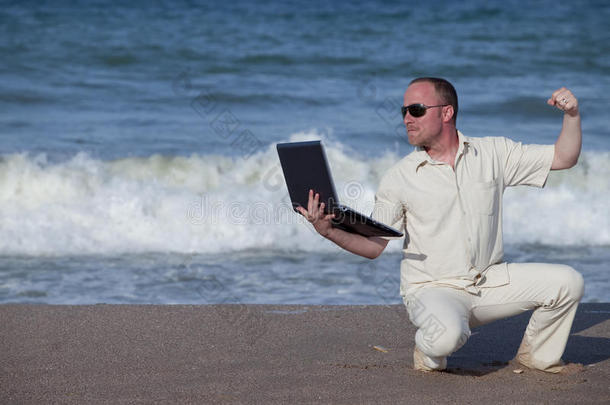 愤怒的男人在海滩上打<strong>笔记本</strong>电脑