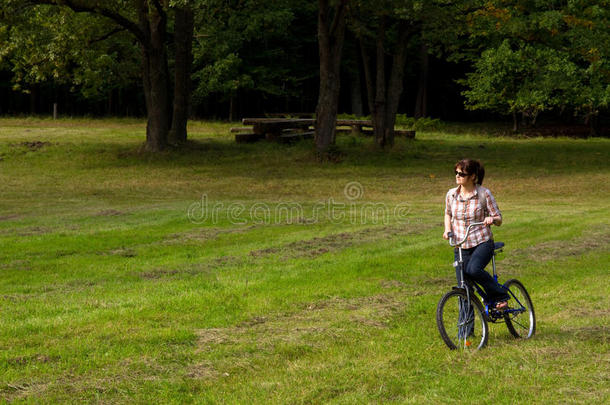 林间空地上骑<strong>自行车</strong>的年轻女子