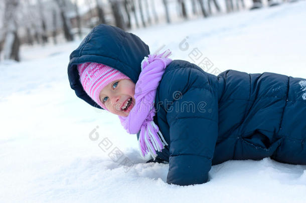 雪地公园里戴着冬天粉红色帽子的小女孩