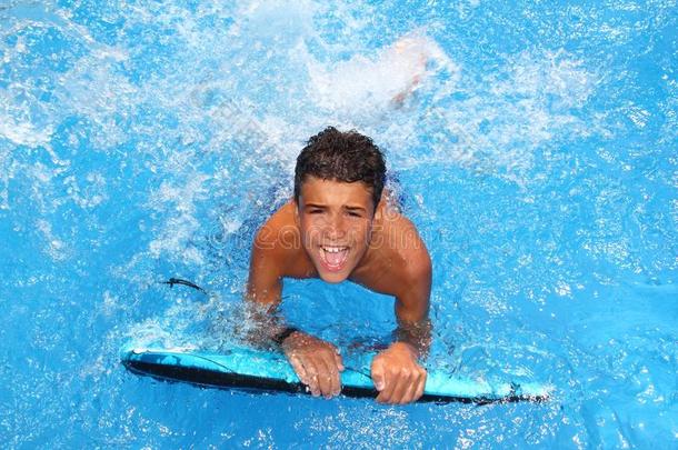 少年少年冲浪板溅蓝水