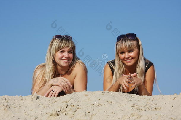 两个年轻漂亮的女人躺在沙滩上