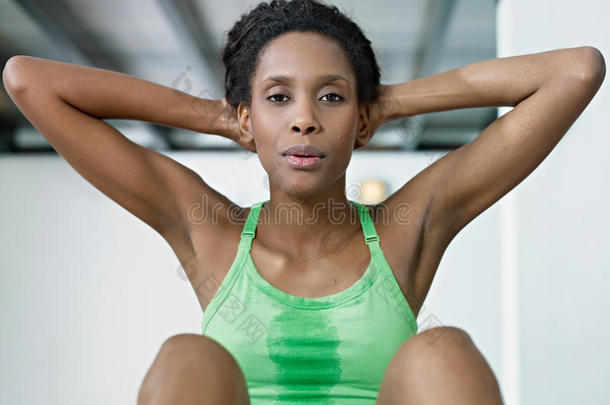 非洲女人在健身房做一系列的仰卧起坐