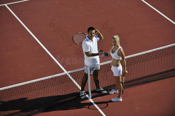 快乐的年轻夫妇在户外打网球